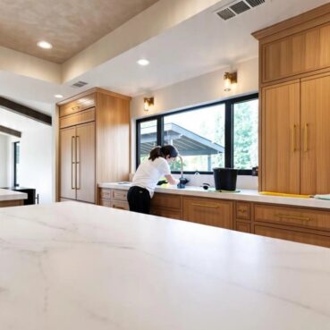 Vieira Cleaning team member cleaning a kitchen counter with professional supplies
