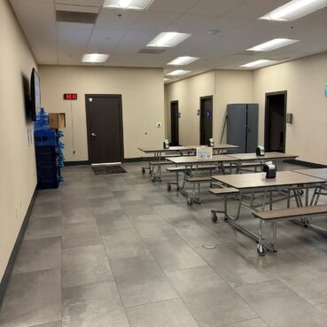 Clean corporate break room with tables and tile flooring serviced by Vieira Cleaning