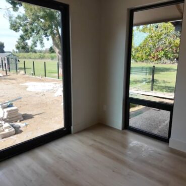 Freshly cleaned empty room with large windows after construction, cleaned by Vieira Cleaning